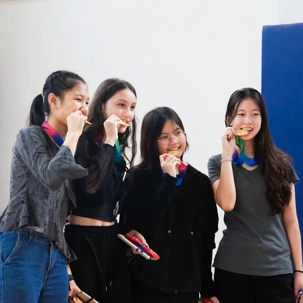 Group of friends celebrate together after the talent show, showing their medals.