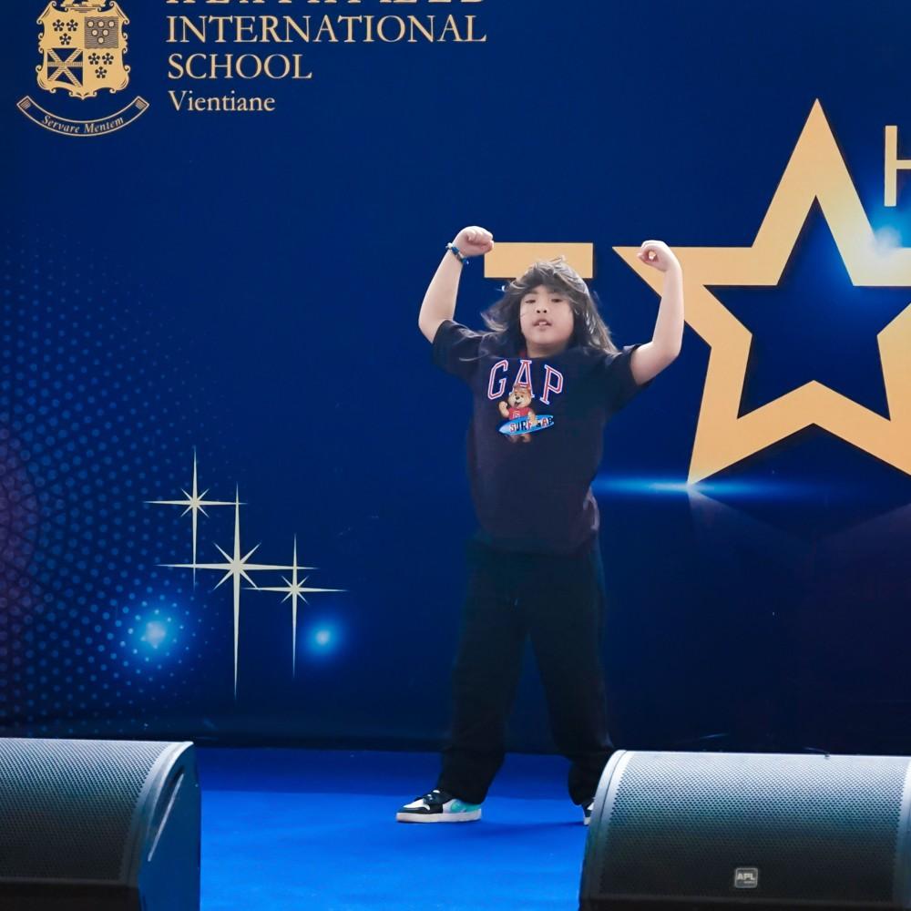 Student strikes a pose on stage during an dance act.