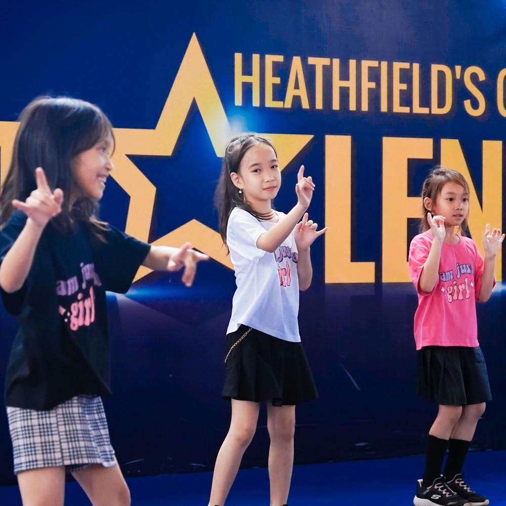 Trio of children dance energetically during their talent show act.