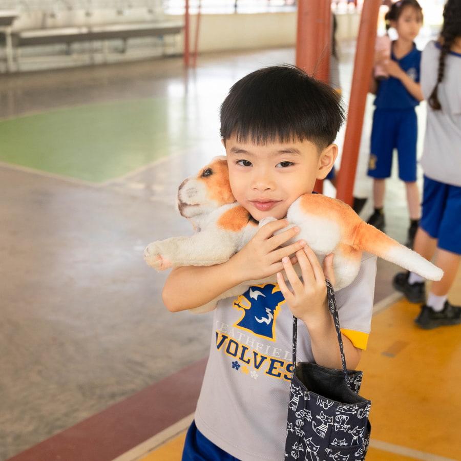 Young student holding stuffed animal toy